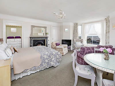 Elegant and comfortably furnished sitting room with double bed and bay window