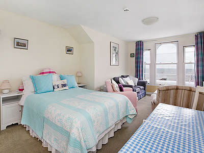 Spacious and comfortably furnished sitting room with double bed and superb, panoramic sea views